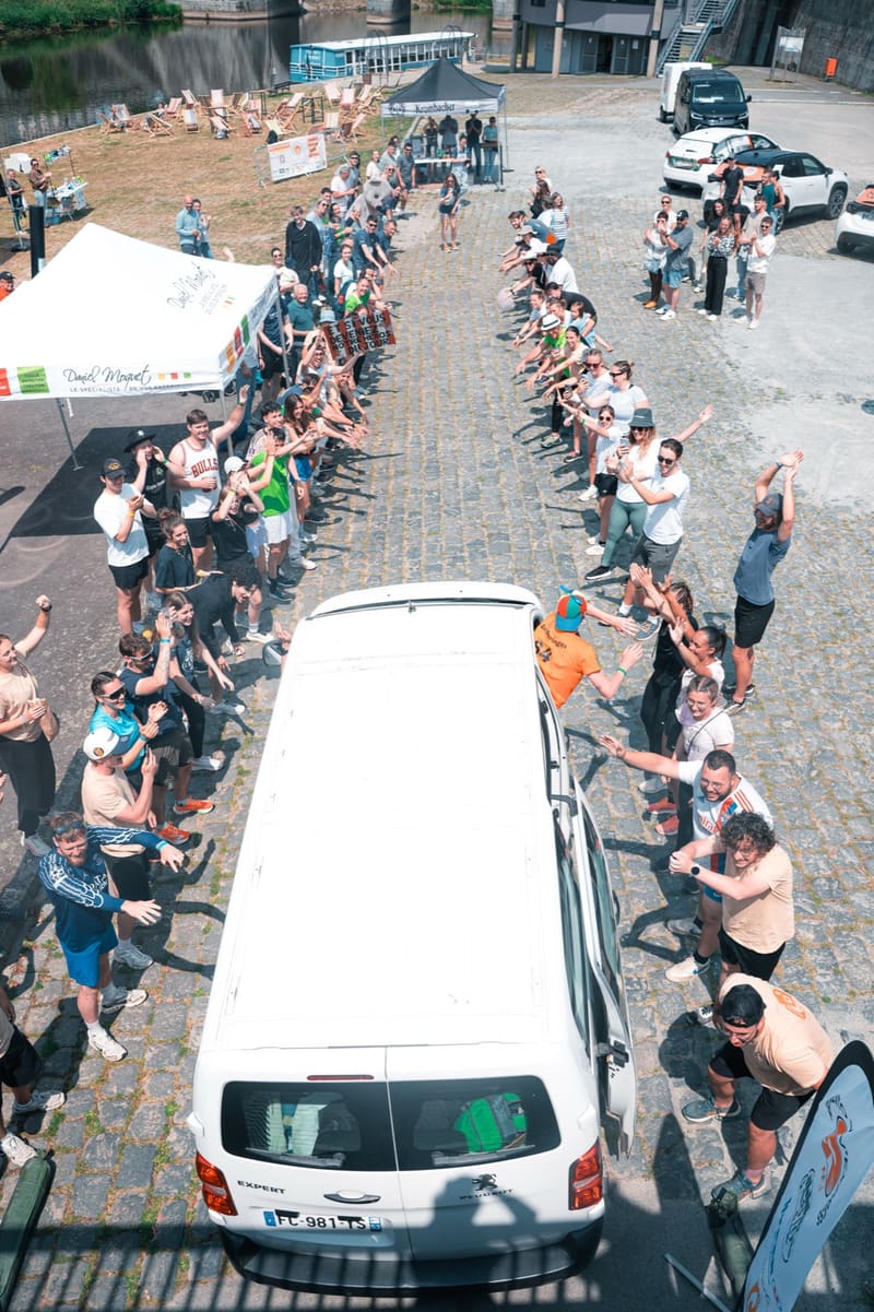 Le van s'élance entre deux haies de participants