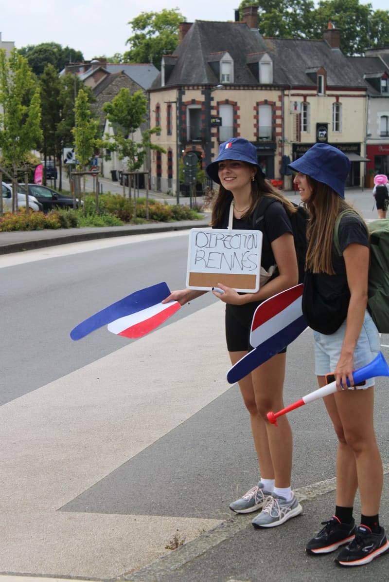 Deux participantes au bord de la route, ardoise « Direction Rennes » à la main